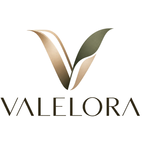 A stylized V logo with leaf-like forms in metallic gold, beige, and dark green above the word VALELORA in dark brown serif lettering on a light cream background.